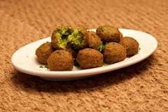 A plate of golden-brown falafel balls on a white dish.