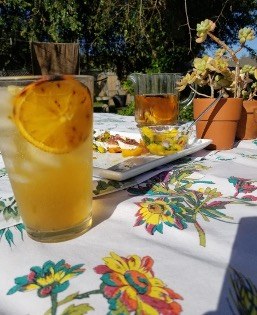 Iced drinks on floral table outdoors.