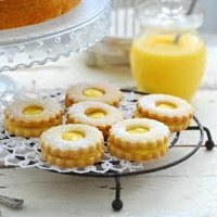 Lemon-filled cookies arranged on a decorative wire rack.