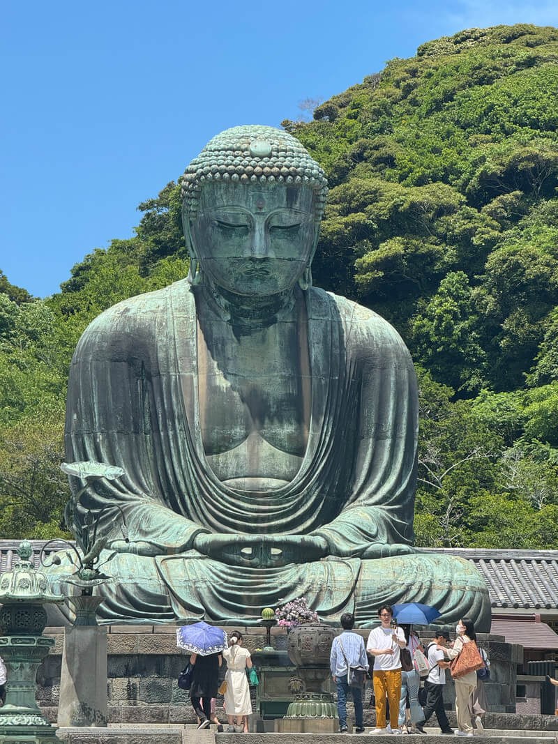 Large statue of Buddha seated in meditation outdoors.