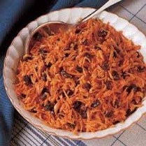 Bowl of shredded carrot salad with raisins.
