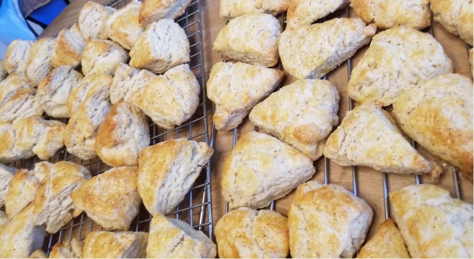 Freshly baked triangular pastries dusted with powdered sugar cooling on a rack.
