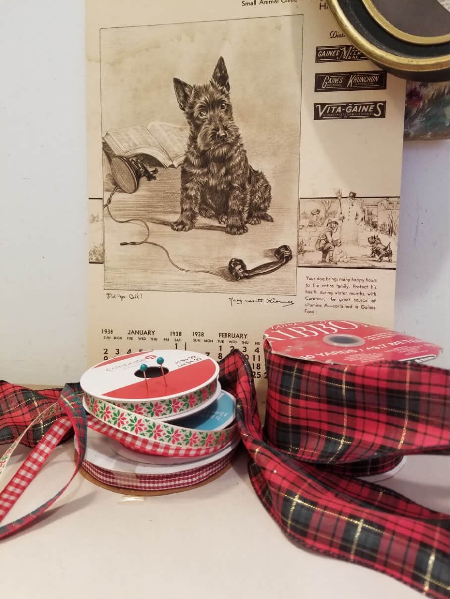 Decorative ribbons and a vintage cat poster on a wall.