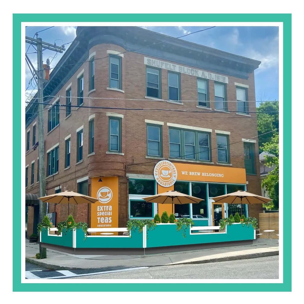 A vibrant coffee shop on a street corner with outdoor seating and a teal fence.