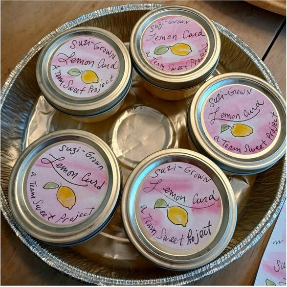 Four jars of lemon honey on a silver tray.