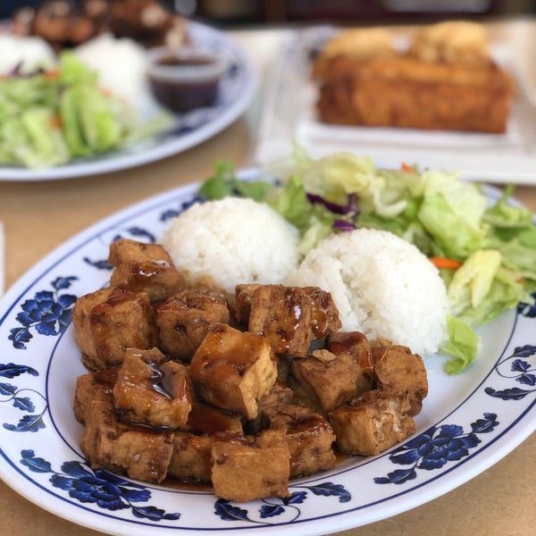 A plate of fried tofu with rice and salad.