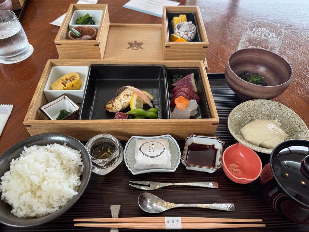 Traditional Japanese meal set with rice, sashimi, and various side dishes.