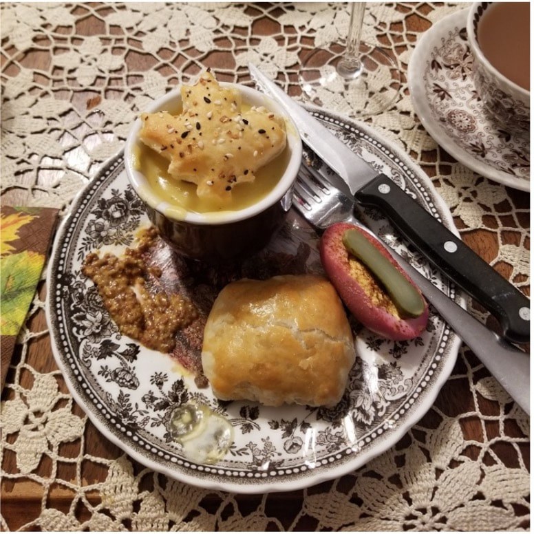 Traditional meal with bread, meat, and vegetables on a decorative plate.