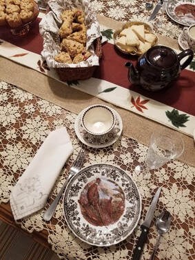 Elegant tea setting with a cup, saucer, and treats on a decorated table.
