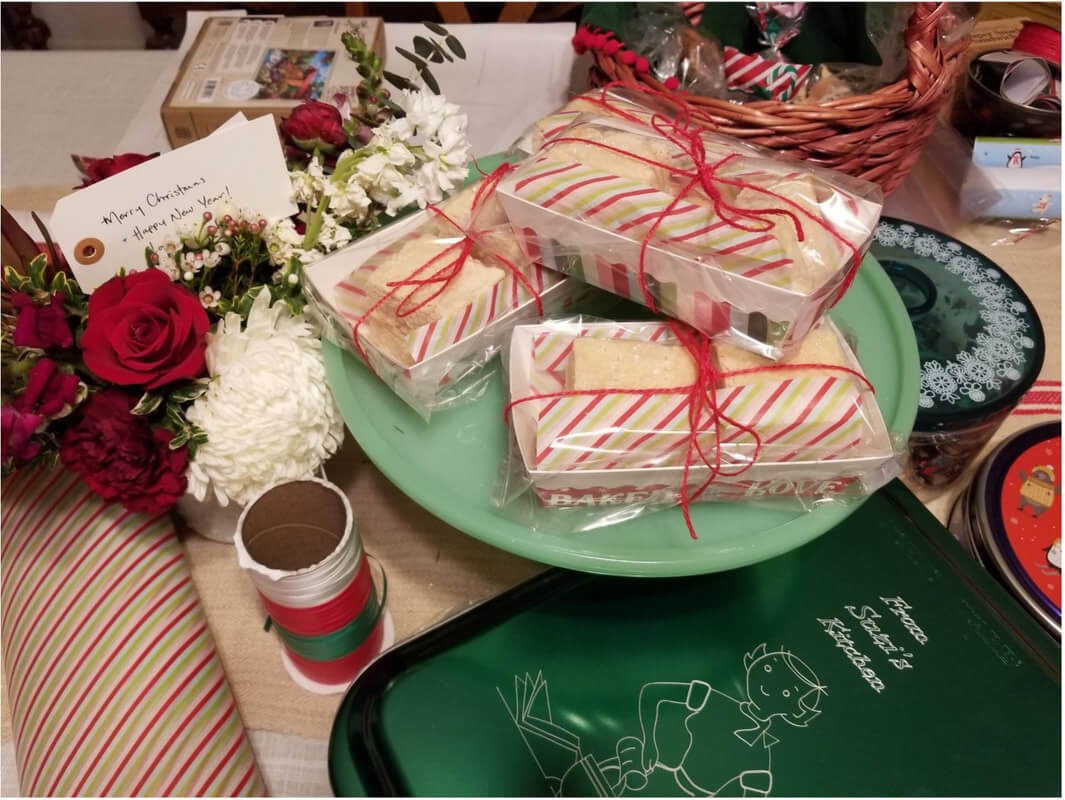 Festive holiday cookies wrapped in clear boxes with ribbon bows.