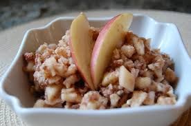 A bowl of apple crisp dessert topped with fresh apple slices.