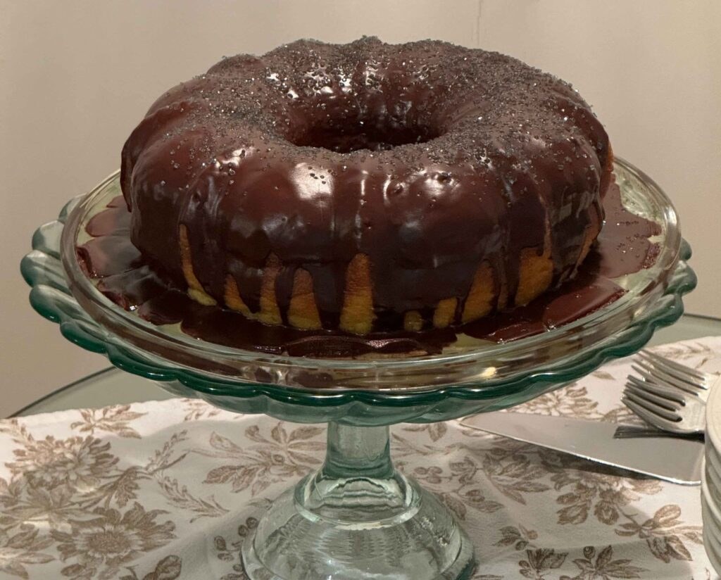 Chocolate bundt cake on a glass stand.