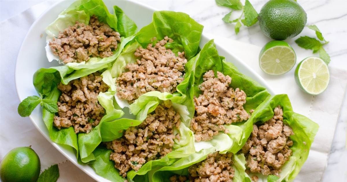 Lettuce wraps filled with savory minced meat on a white plate.