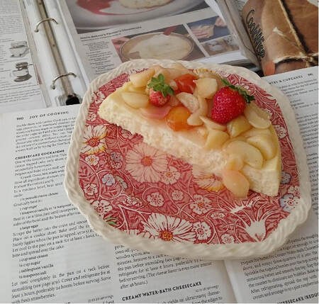 A slice of fruit-topped cheesecake on patterned plate.