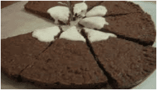 Chocolate brownies with cream dollops on top, sliced into pieces.