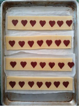 Rows of rectangular cookies with chocolate hearts on top.