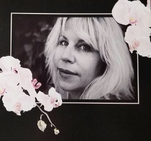 Black and white portrait of a woman framed with white orchids.