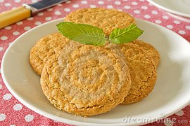 Plate of oatmeal cookies garnished with fresh mint leaves.