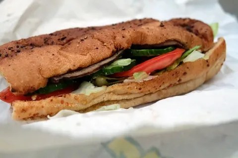 A close-up of a sandwich with vegetables and meat.