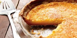 A slice of pumpkin pie in a dish with a golden crust.