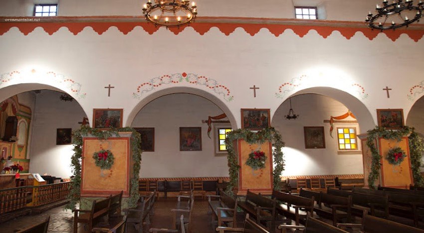 Interior of a historic church with wooden pews and decorative arches.