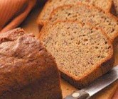Sliced freshly baked banana bread on a cutting board.
