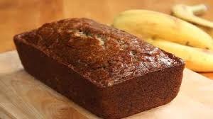 A freshly baked loaf of banana bread on a wooden surface.