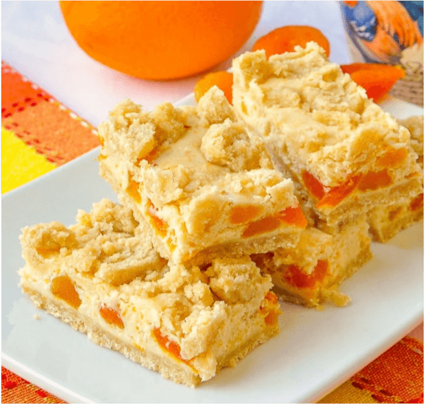 Creamy orange-flavored dessert bars on a white plate.