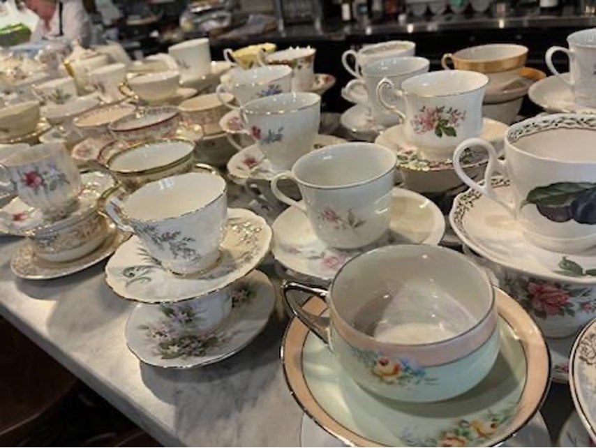 A collection of elegant floral teacups and saucers arranged on a table.