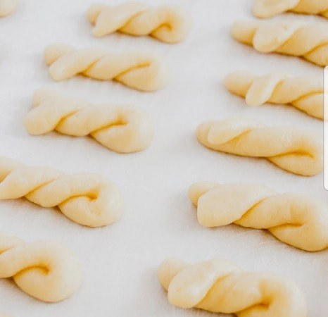 Unbaked twisted dough pieces arranged on a baking sheet.