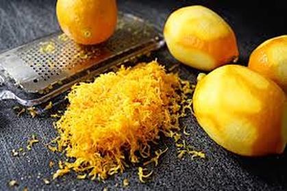 Fresh mangoes with shredded mango peel on a dark surface.