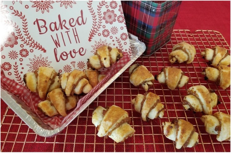 Homemade crescent rolls on cooling racks with a loving baked sign.