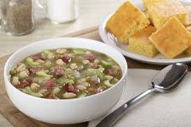 Bowl of hearty pea and ham soup with cornbread on the side.