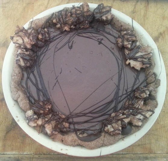 Chocolate cake topped with walnuts and drizzled chocolate.