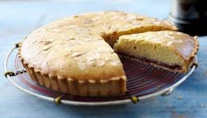 A round cake with a slice cut out on a cooling rack.