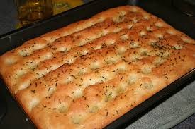 Freshly baked focaccia bread sprinkled with herbs.