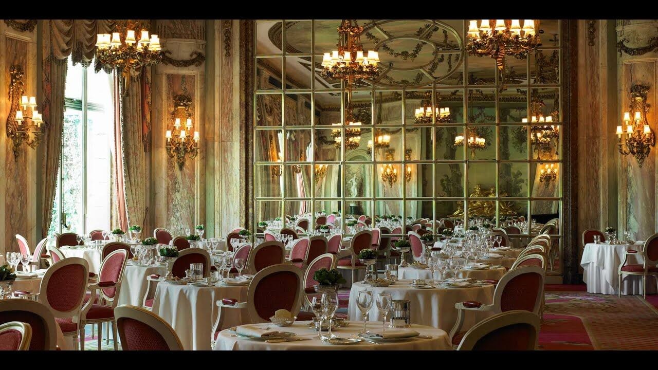 Elegant dining room with chandeliers and ornate mirrors.