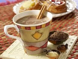 A warm cup of spiced chai tea with cinnamon sticks.