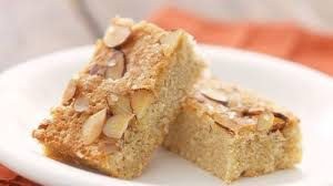 Two pieces of almond cake with sliced almonds on top.