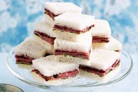 Stack of layered dessert bars with a fruit filling and white topping.