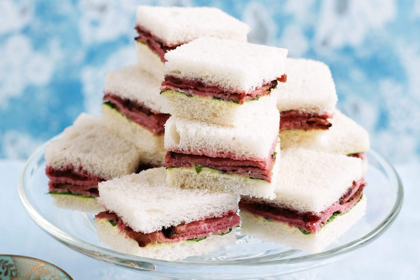 Stack of frosted layered dessert bars with jam filling.