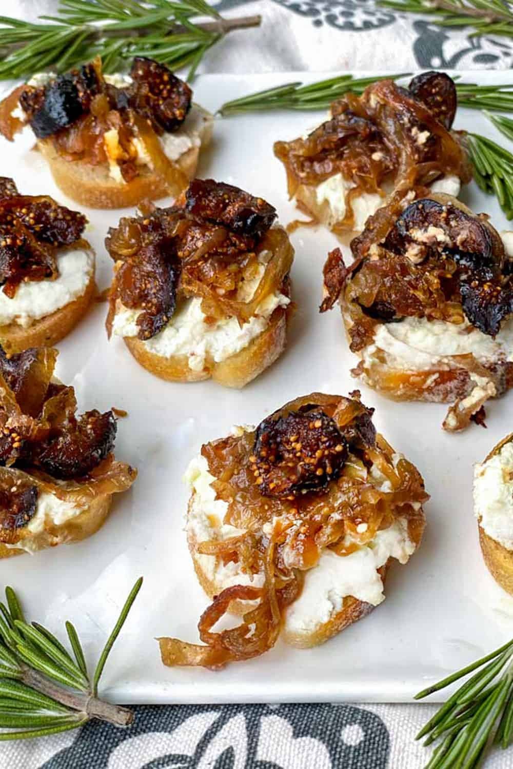 Appetizers with creamy cheese, caramelized onions, and nuts on sliced bread.