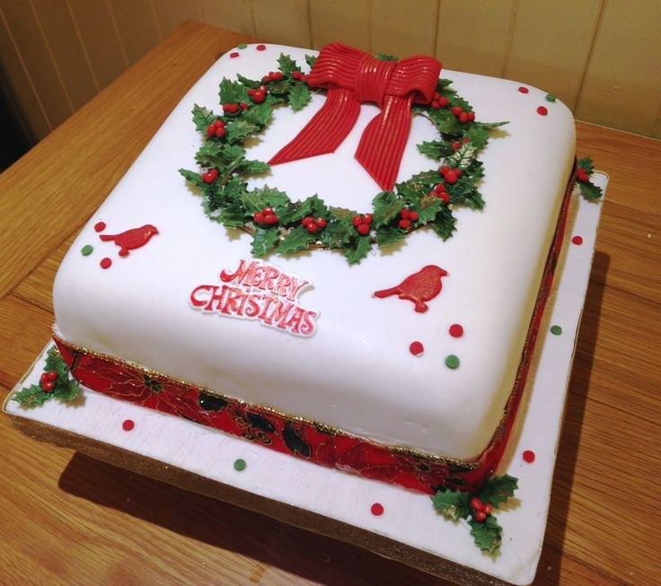 Square Christmas cake decorated with a festive wreath and red bow.