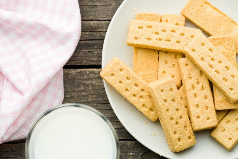 Shortbread cookies on a plate with a glass of milk.