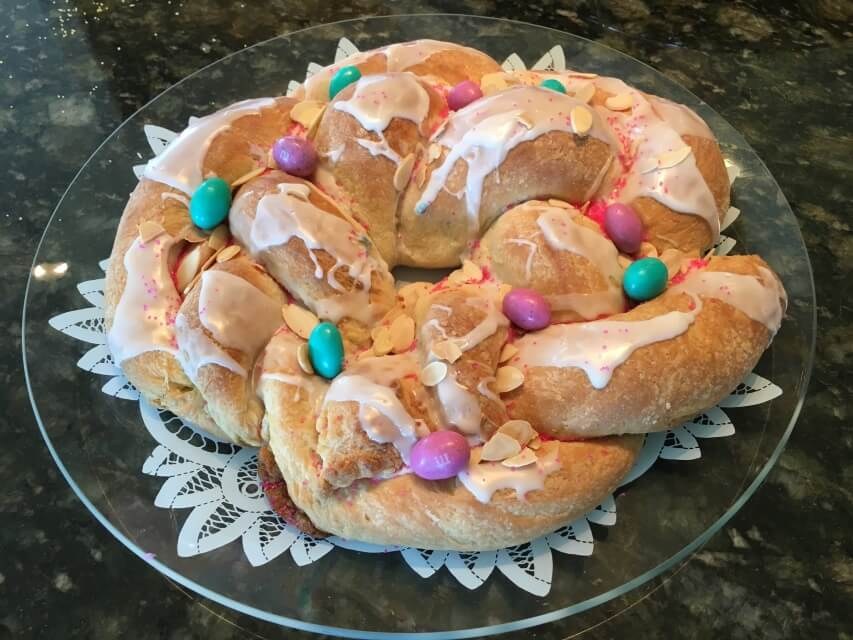 A festive pastry wreath decorated with colorful candies and icing.