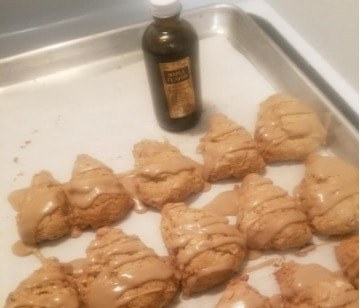 Baked star-shaped cookies drizzled with caramel on a tray.