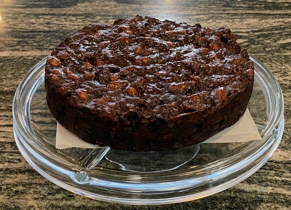 Rich fruitcake on a glass stand.