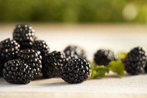 Close-up of fresh blackberries on a wooden surface.