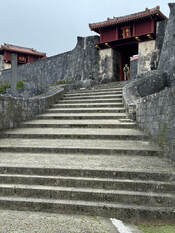 Stone stairs leading up to a traditional building with red accents.