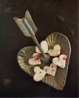 Heart-shaped tray with arrow and candies.